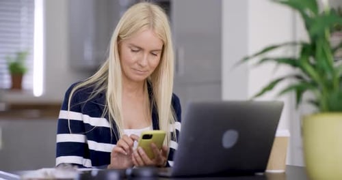 Woman Using Smartphone and Laptop While Working