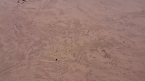 Lone Hiker Walking Across Desert Landscape