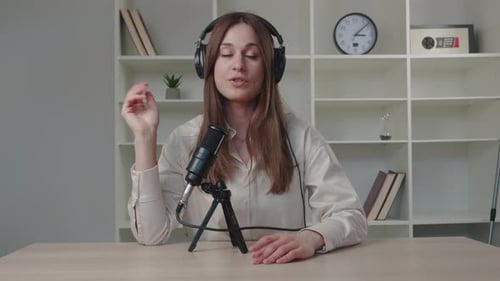 Woman Speaking Into Microphone At Desk