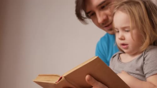 Father and Daughter Reading a Book Together