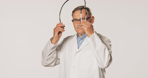 Mature Doctor Wearing Stethoscope in Studio Setting