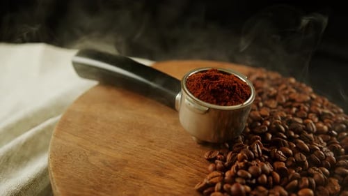 Ground Coffee in Portafilter on Wooden Board with Coffee Beans and Dissipating Steam