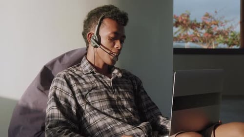 Male Helpdesk Operator Consulting Client by Internet