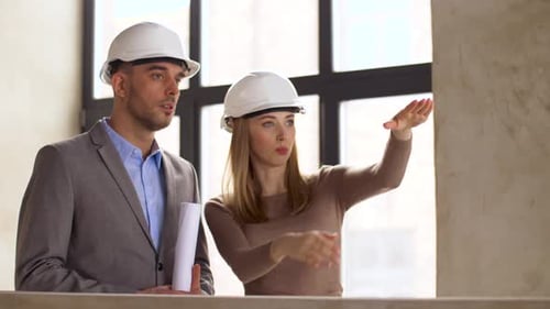 Architects with Blueprint and Helmets at Office 28