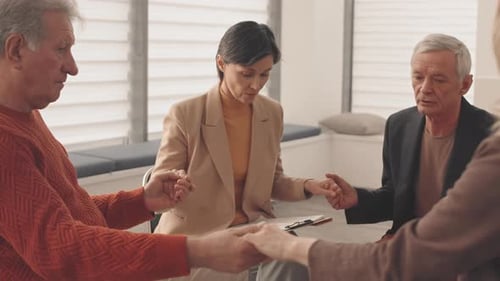 Group Holding Hands in Circle During Therapy Session