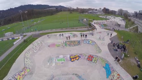 Drohnenaufnahme eines jungen Mannes, der ein BMX-Fahrrad in einem mit Graffiti bedeckten Beton-Skatepark fährt