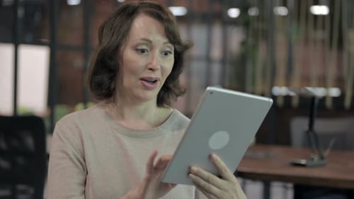 Excited Woman Celebrates Good News on Tablet