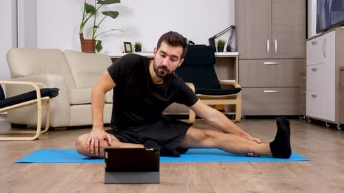 Man Stretching on Yoga Mat at Home