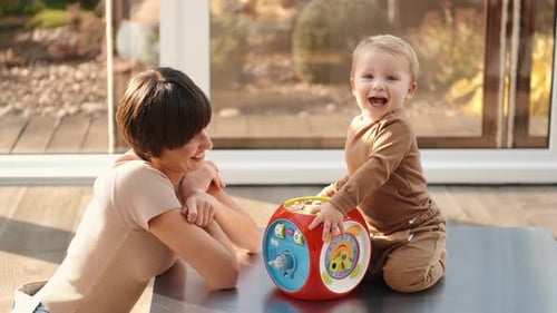 Woman and Baby Play with Colorful Toy