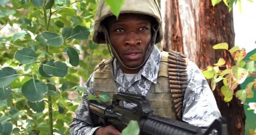 Soldier Holding Rifle in Green Forest