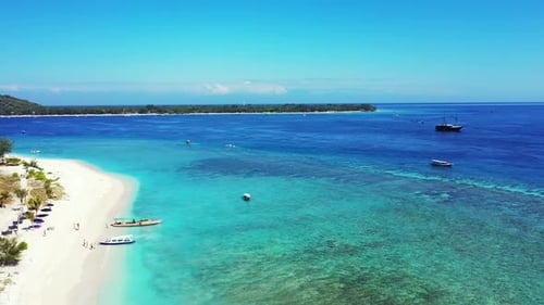 Paradise tropical bay with white sandy beach and blue turquoise calm lagoon where boats floating on