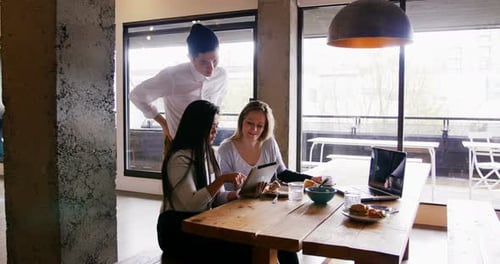 Business people discussing over digital tablet in cafeteria at office 4k