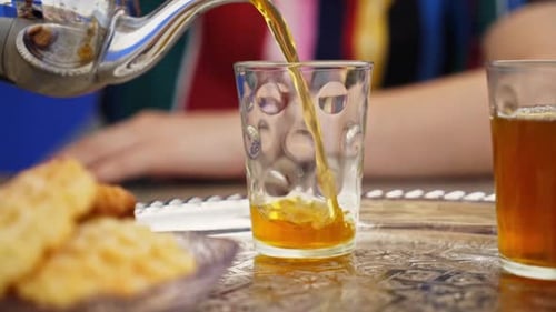 Close-up do tradicional chá de menta sendo servido em vidro, bebida cultural marroquina