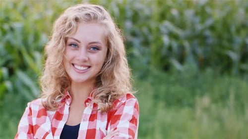 Portrait of a Young Woman Against the Background of a Corn Field
