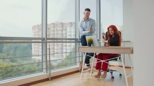 Sales Managers Dance in the Business Office After a Successful Deal. Office Workers Man and Woman