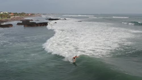 Aerial View of Surfer Riding Blue Ocean Wave. Drone Shot Surfing Ocean Lifestyle, Extreme Sports.
