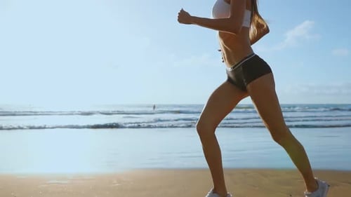 Beautiful Sporty Women in White Sneakers Running Along a Beautiful Sandy Beach, Healthy Lifestyle