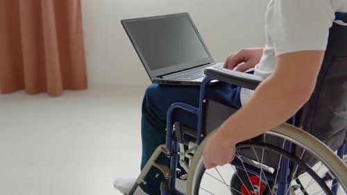 Adult Uses Laptop While Seated in Wheelchair