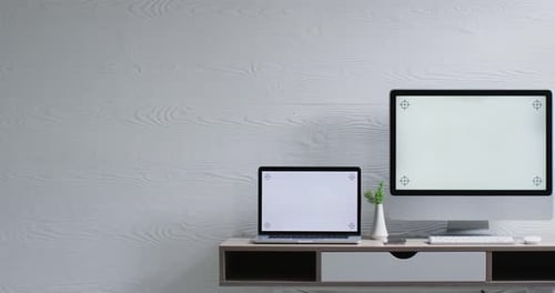 Video of computer and laptop on wooden table with copy space in office