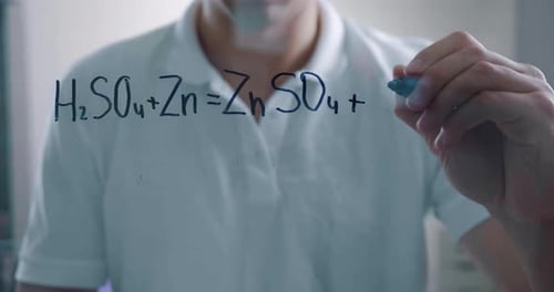 Man Writes Chemical Equations on Transparent Board