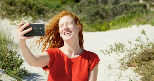 Woman taking selfie with mobile phone at beach 4k