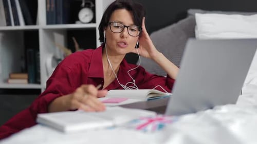 Woman Talking Online Via Laptop on Bed