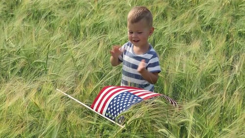 Little Boy with Flag Clapping in Grassy Field