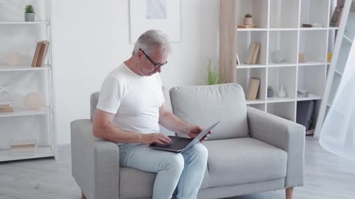 Senior Man Using Laptop at Home