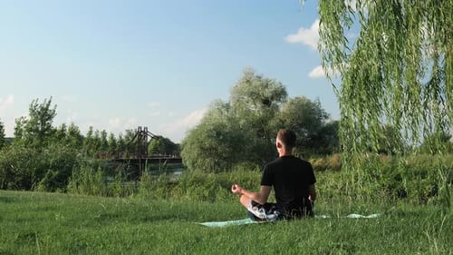 Man Meditating Outdoors on Yoga Mat