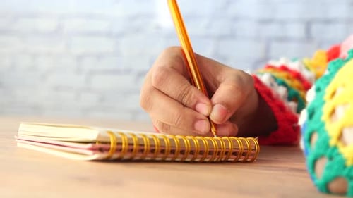 Side View of Women Hand Writing on Notepad with Copy Space