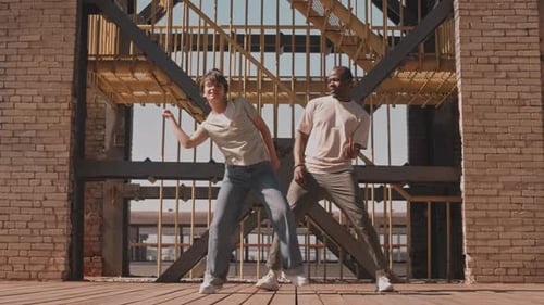 Young People Energetically Dancing Outdoors in Urban Setting