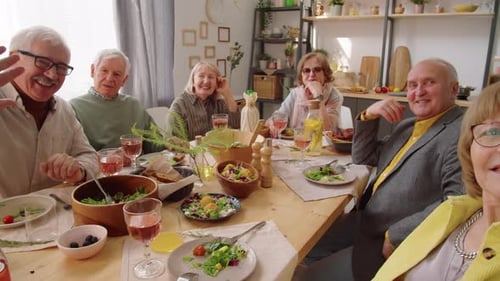 Senior Friends Enjoying Meal and Waving