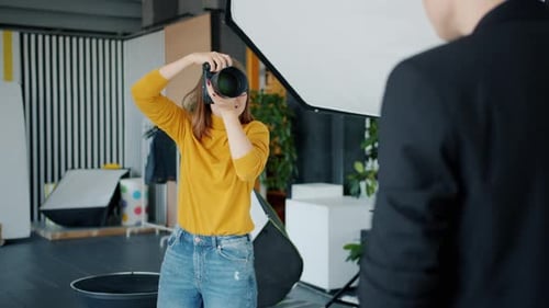 Professional Photographer Taking Pictures of Male Model Using Camera in Studio