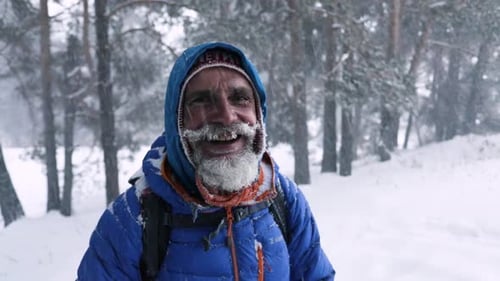 Smiling Man in Snowstorm in Winter Forest