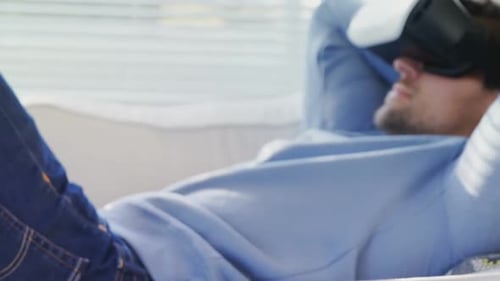 Man Relaxes on Couch with Virtual Reality Headset