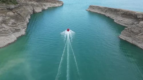 Top view of a mountain river in the canyon and boat sailing along a turquoise river among the rocks
