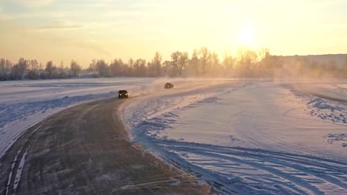 Cars Driving on Snowy Road During Sunrise