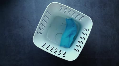 Medical Face Mask and Glove in White Laundry Basket