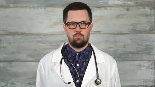 Doctor in White Coat Looking at Camera
