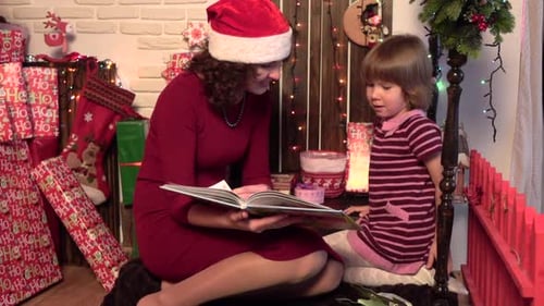 Woman and Girl Reading Christmas Storybook