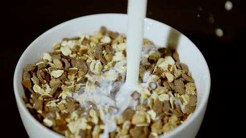 Milk Being Poured over Cereal in Bowl