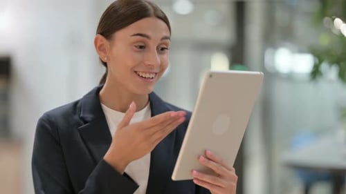 Woman Holding Tablet Video Chatting in Office