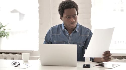 African Man Doing Paperwork in Office