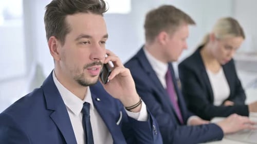 Portrait of Focused Businessman Talking on Smartphone in Office