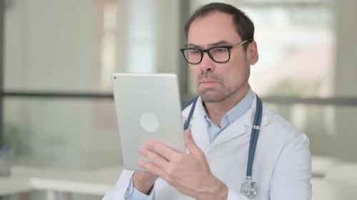 Doctor Using Tablet in Bright Office