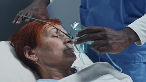 Senior Woman Receives Oxygen in Hospital Bed
