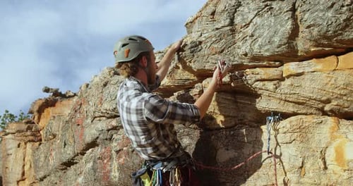 Mounatineer trying to adjust the climbing equipment