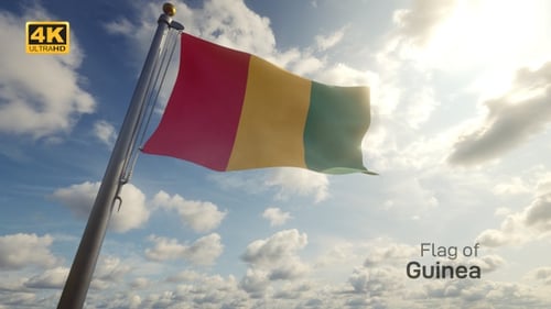 Guinea Flag Waving on a Flagpole Against a Sunny Sky