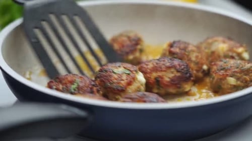 Unerkennbare Person kocht Fleischbällchen auf Bratpfanne mit Öl