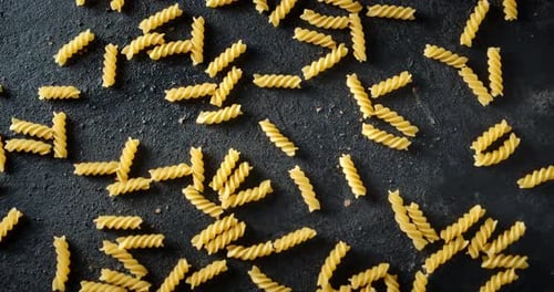 La pasta Fusilli seca sobre la mesa gira lentamente